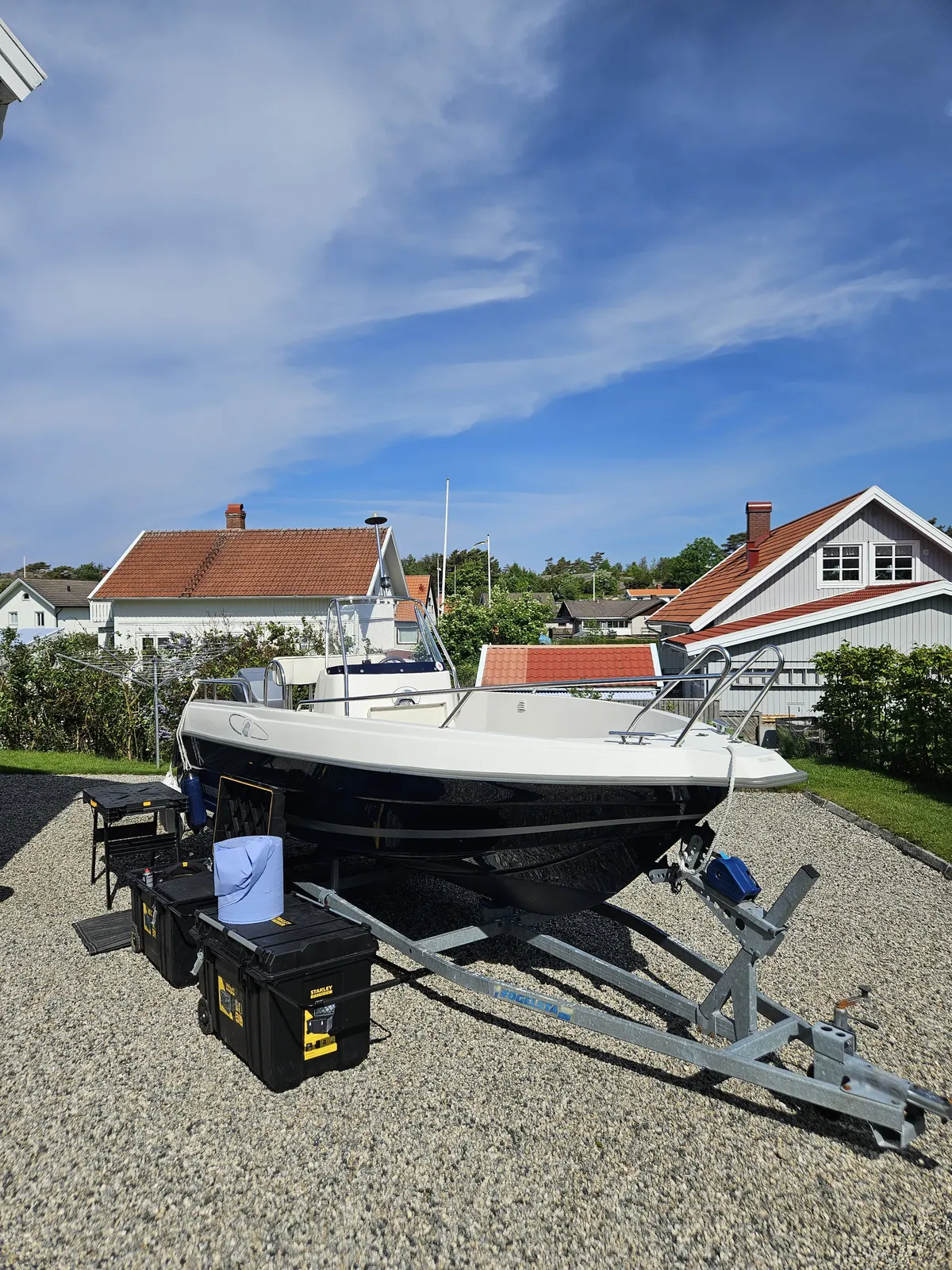 Båt på trailer framför sjöbodarna